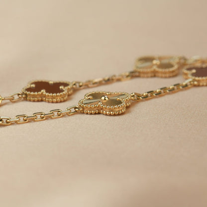 [LUXE] PULSERA DE ORO CON 5 MOTIVOS DE TRÉBOL Y CORNALINA 